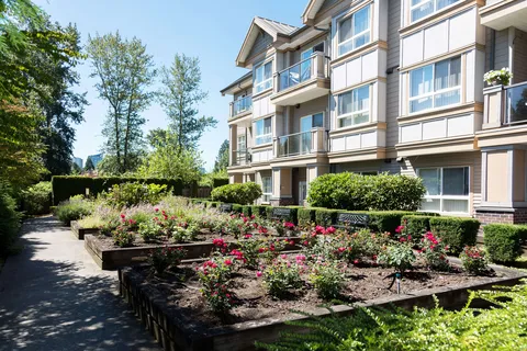 Raised flower beds beside the building and a paved walking path