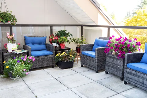 Outdoor seating with blue cushions and potted flowers