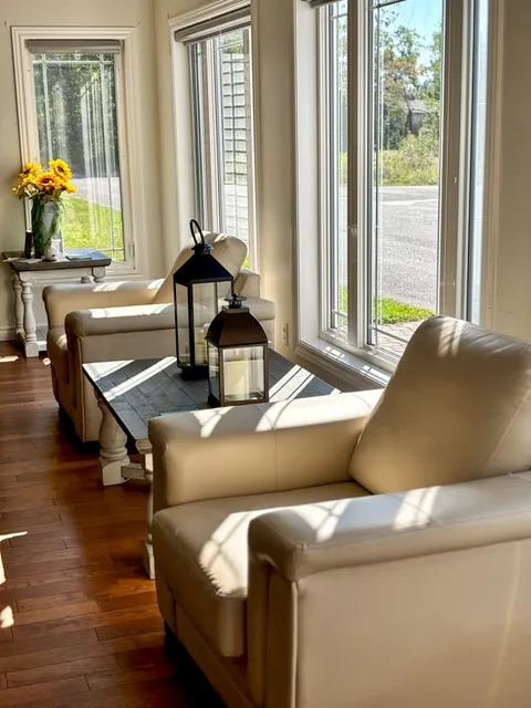 Two upholstered chairs beside a window and small table.