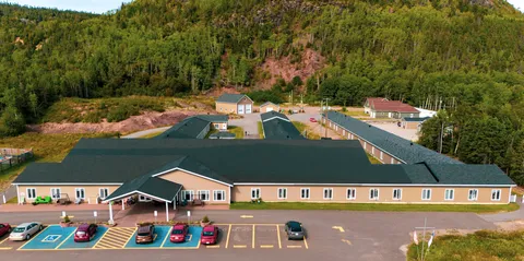 Aerial view of the residence with dark roofs and landscaped grounds.