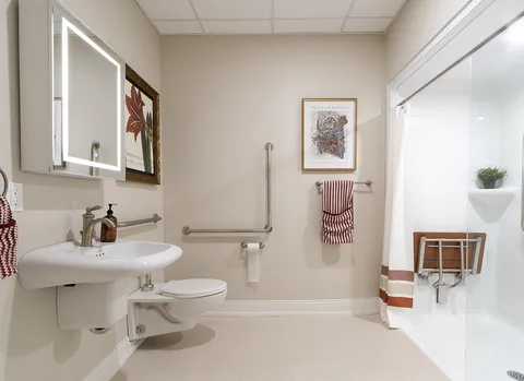 Bathroom with a pedestal sink, toilet and accessible shower