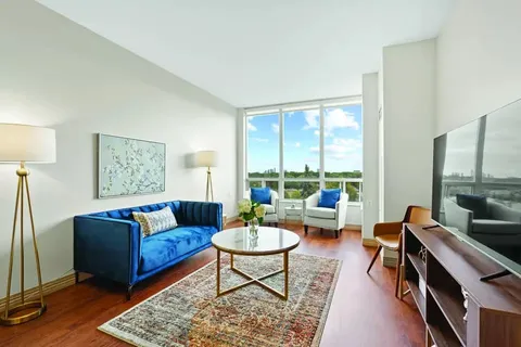 Sitting area with a blue sofa, armchairs, coffee table and television