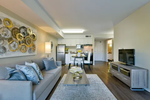 Suite sitting area with a sofa, television, dining table and kitchen