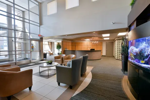 Lobby seating beside large windows and a reception counter