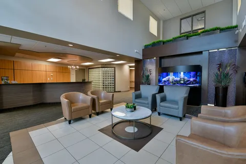 Armchairs and a small table near a reception desk and aquarium