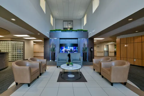 Lobby with armchairs, a round table and a large aquarium