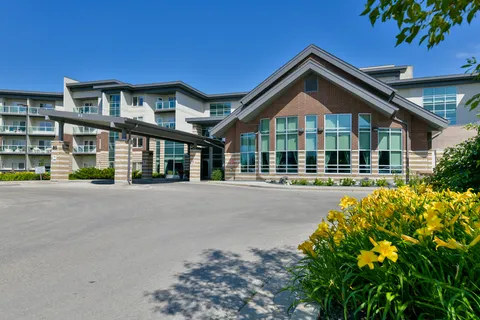 Residence entrance with a peaked roof and flower beds