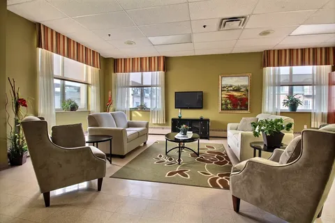 Sitting room with sofas and armchairs facing a television