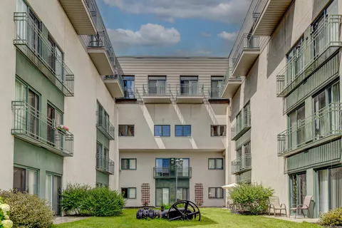 Residence wings around a courtyard with balconies and lawn