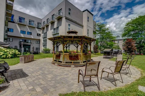 Courtyard with a wooden gazebo, benches and patio chairs