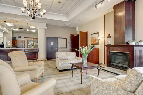 Lounge with pale seating, a fireplace and a reception desk