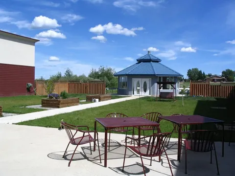 Courtyard with patio tables, raised planting beds and a gazebo.