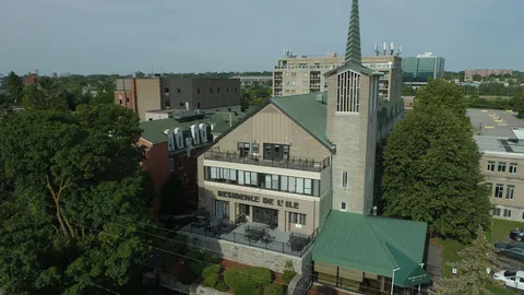 Residence with a green roof and tower, a raised terrace and mature trees