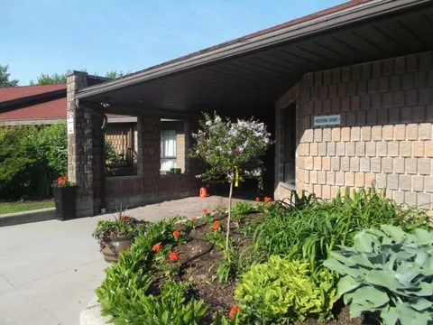 Covered residence entrance beside a raised flower bed