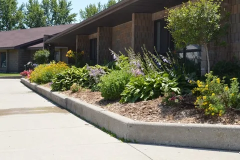 Brick residence beside a walkway and planted flower beds