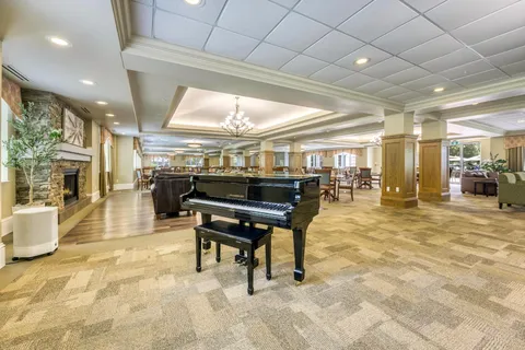 Lounge with armchairs, sofas and a grand piano