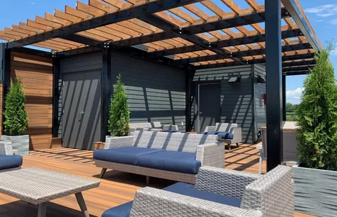 Rooftop terrace seating beneath a wooden pergola.