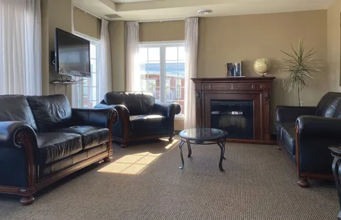 Lounge with leather seating and a fireplace.