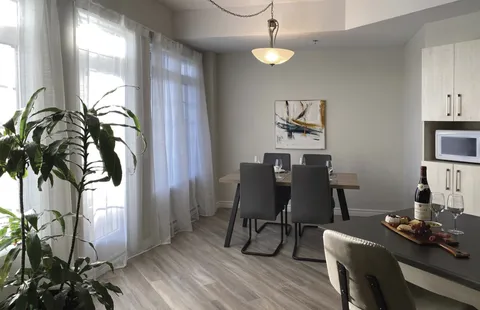 Kitchen and dining area beside large windows.