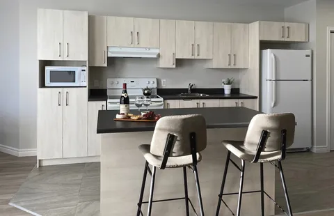 Apartment kitchen with white cabinets and an island.