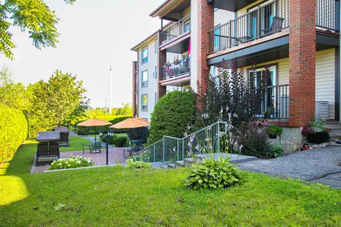 Landscaped lawn and patio beside the residence balconies.