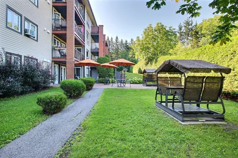 Garden lawn with a walking path and covered swings beside the building.