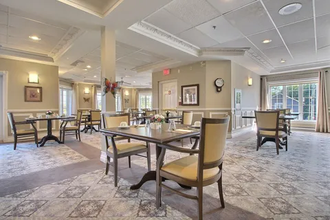 Dining room with set tables and upholstered chairs.