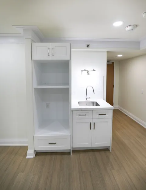 Kitchenette with white cabinets, a sink and open shelves