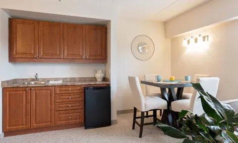 Apartment kitchenette and dining table with chairs.