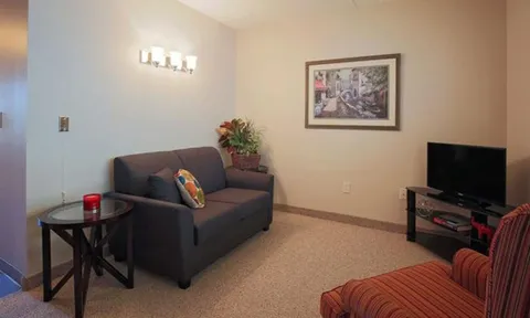 Sitting room with a sofa, armchairs and a television.