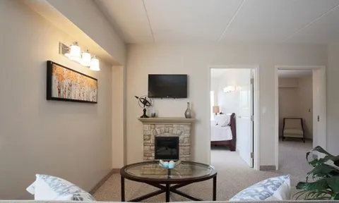 Suite sitting area with a fireplace and an adjoining bedroom.