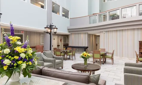 Atrium lounge with seating, tables and flower arrangements.