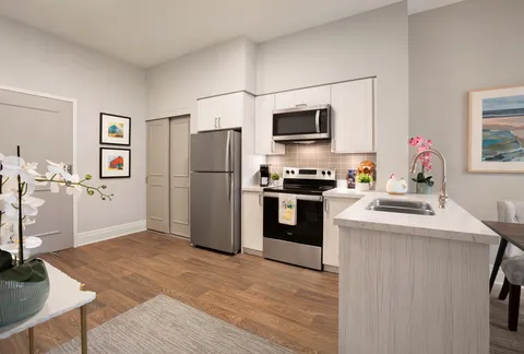 Suite kitchen with cupboards, appliances and an island counter.