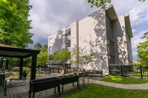 Outdoor patio with a canopy, tables and chairs beside the building