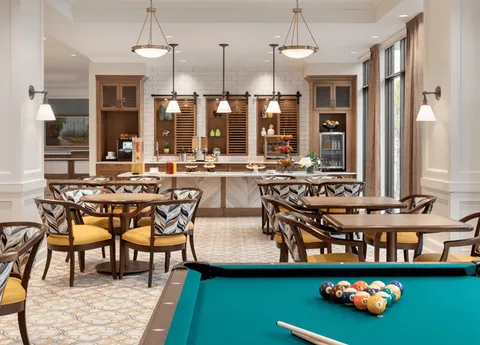 Bistro with tables and a pool table in the foreground.