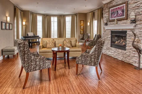 Lounge with armchairs, a sofa and a stone fireplace.