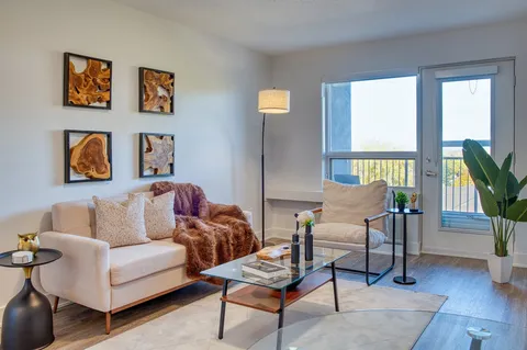 Suite living area with a sofa, armchair and balcony doors.