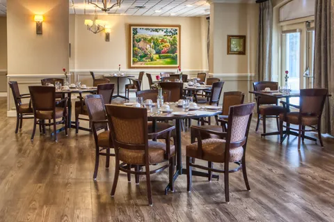 Dining room with set round tables and dark wood chairs.