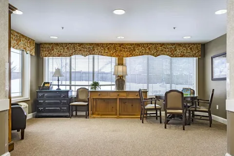 Room with a round table, chairs, cabinets and wide windows
