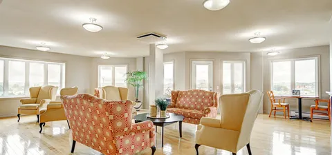 Sunroom with armchairs and floor-to-ceiling windows.