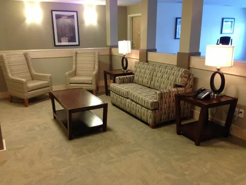Lounge with a patterned sofa, two chairs, a coffee table and lamps.