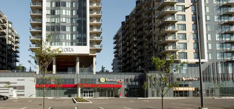 Apartment building with balconies beside parking spaces and landscaped planting beds