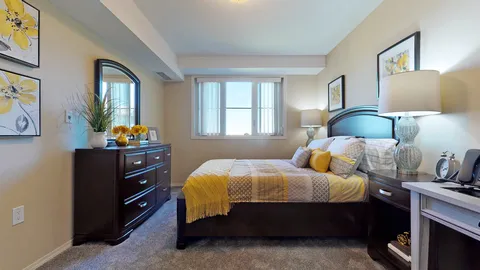Bedroom with a bed, dresser, bedside tables and a window