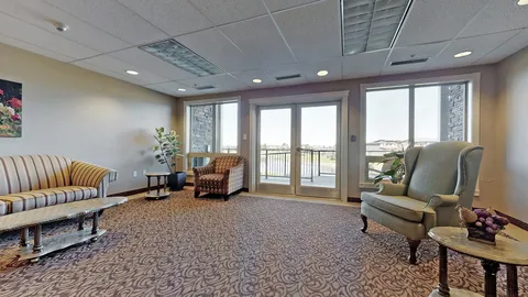 Room with sofas, armchairs and large windows beside a glazed door