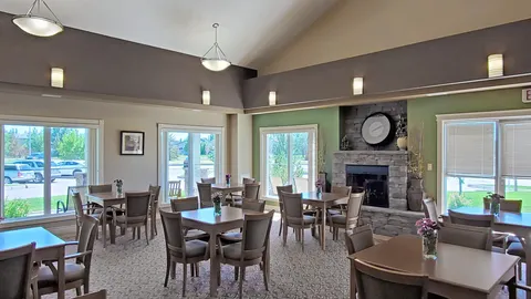 Dining room with tables and chairs around a stone fireplace