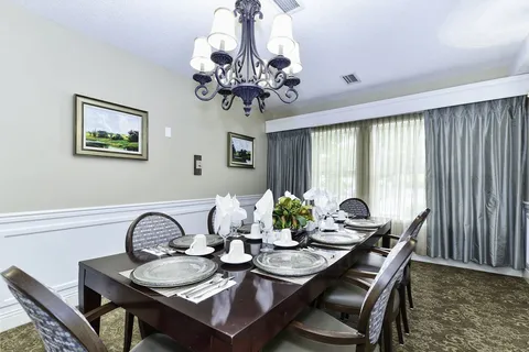 Private dining room with a long set table and chandelier.