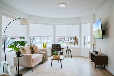 Suite living area with a sofa, armchairs and large windows.