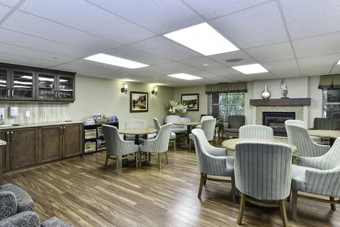 Lounge with armchairs, a service counter and fireplace.