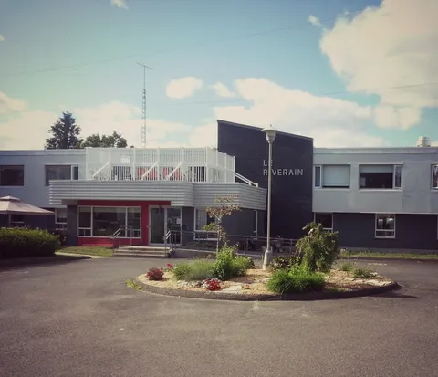 Two-storey residence exterior with a driveway, landscaped island and upper terrace