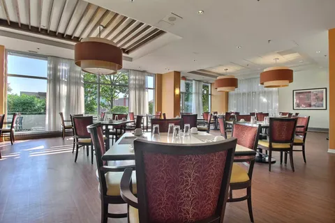Dining room with tables, red chairs and large windows
